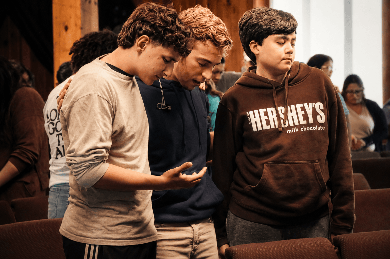 3 Jovens orando juntos lado a lado