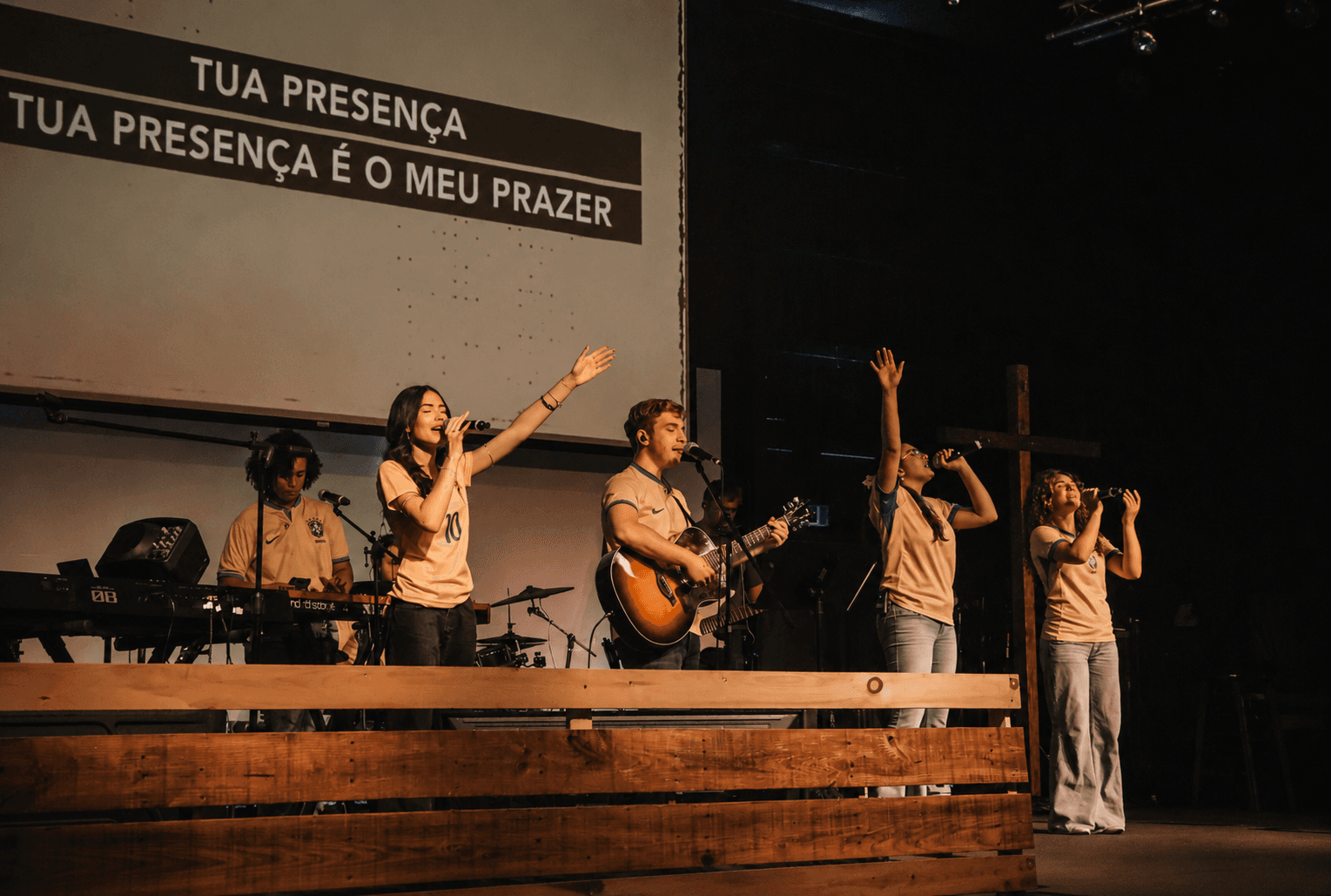 Grupo de jovens cantando e tocando na igreja 